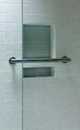 Recessed niche in shower with glass tile and grab bar